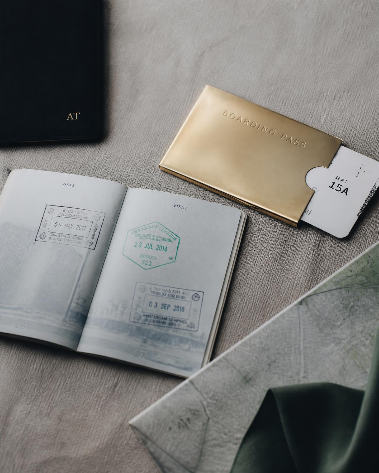 Passport with visa stamps and a boarding pass holder on linen
